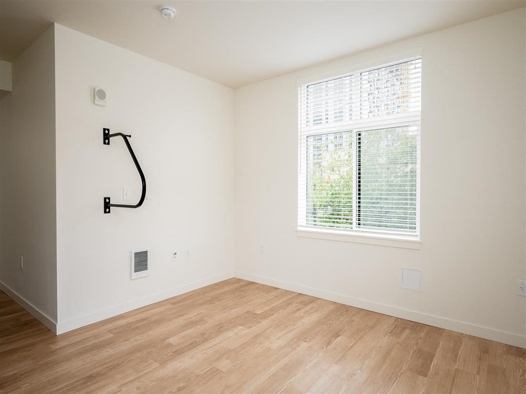 an empty room with a large window and wooden floors