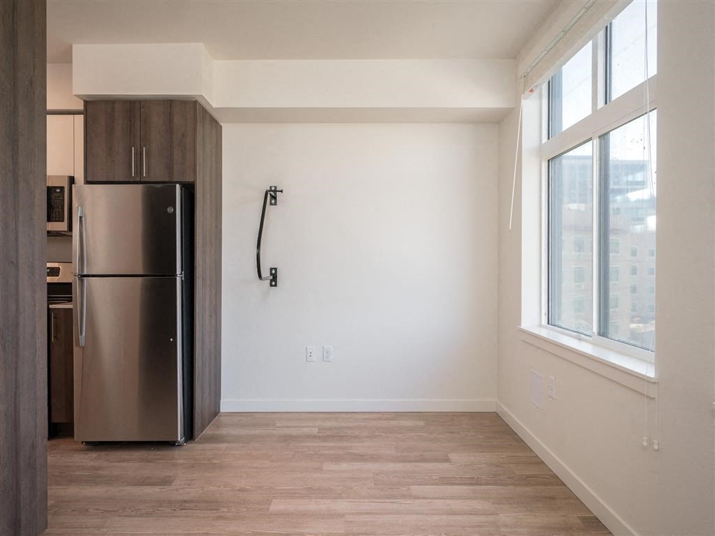 an empty room with a refrigerator and a window