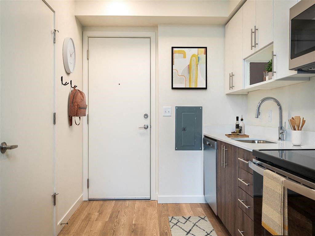 a small kitchen with a sink and a door to the bathroom