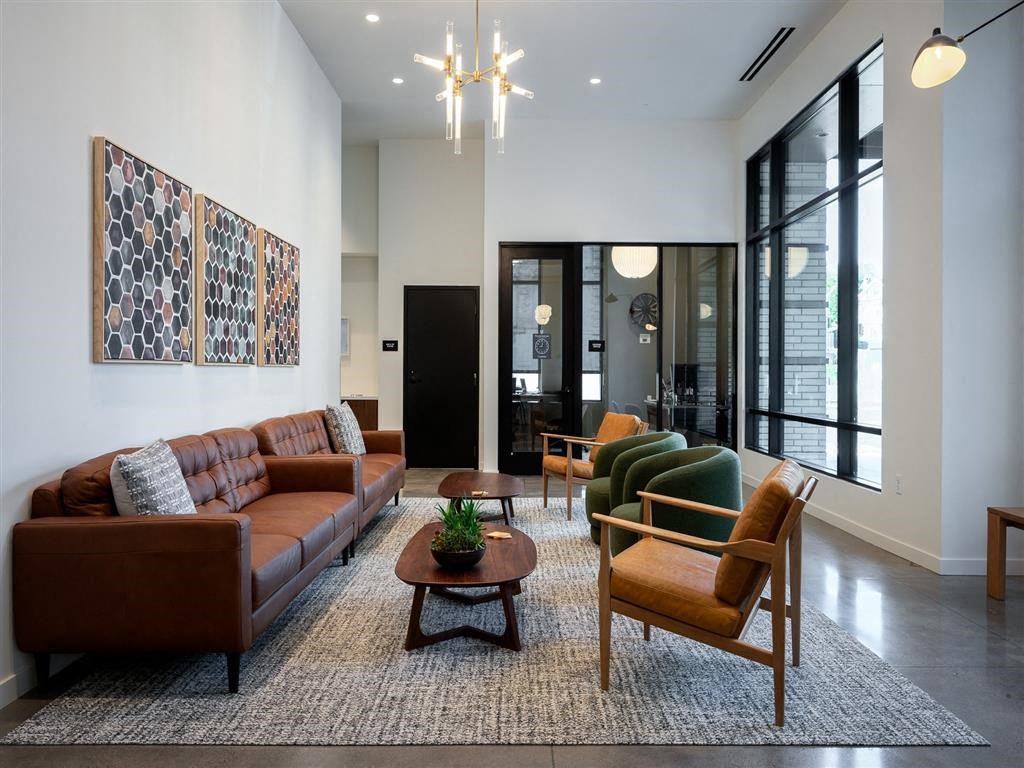 a living room with a couch and chairs and a rug