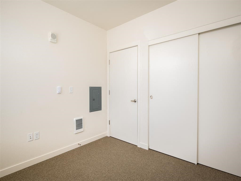 a bedroom with white walls and white doors and carpet