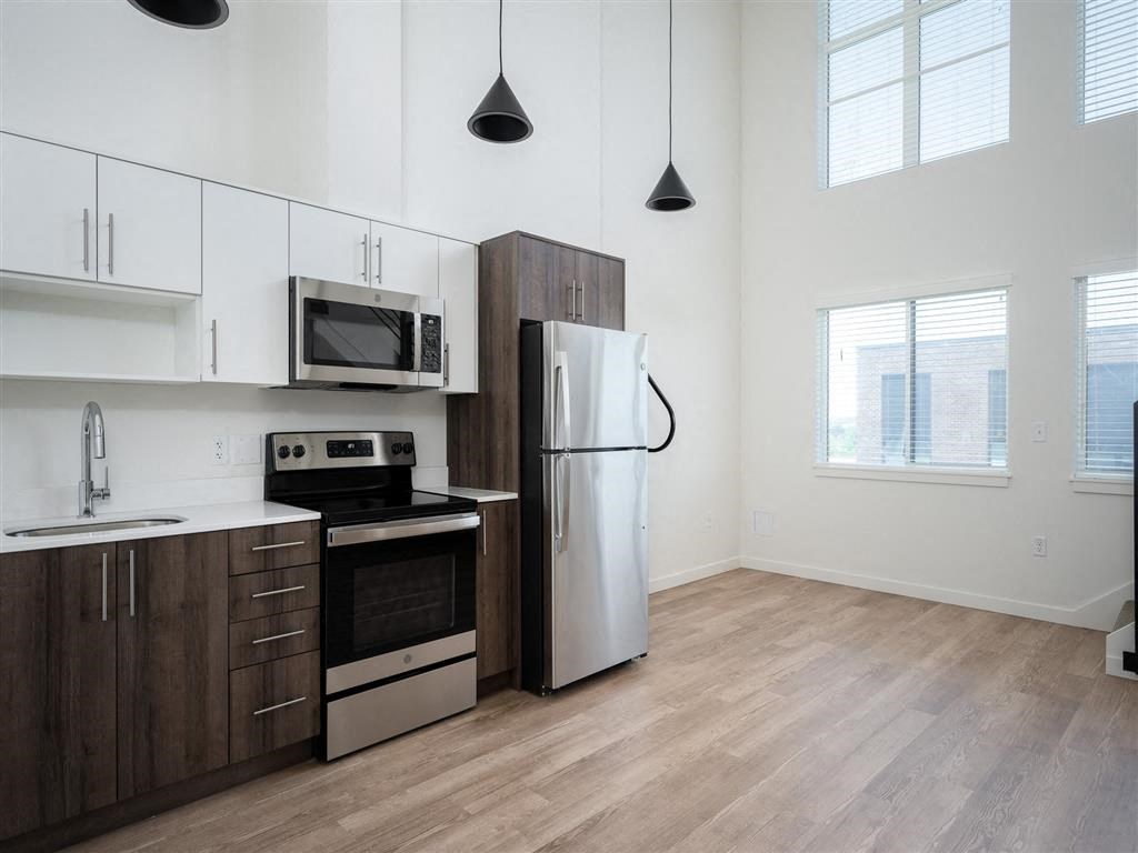 a kitchen with stainless steel appliances and white cabinets and a window