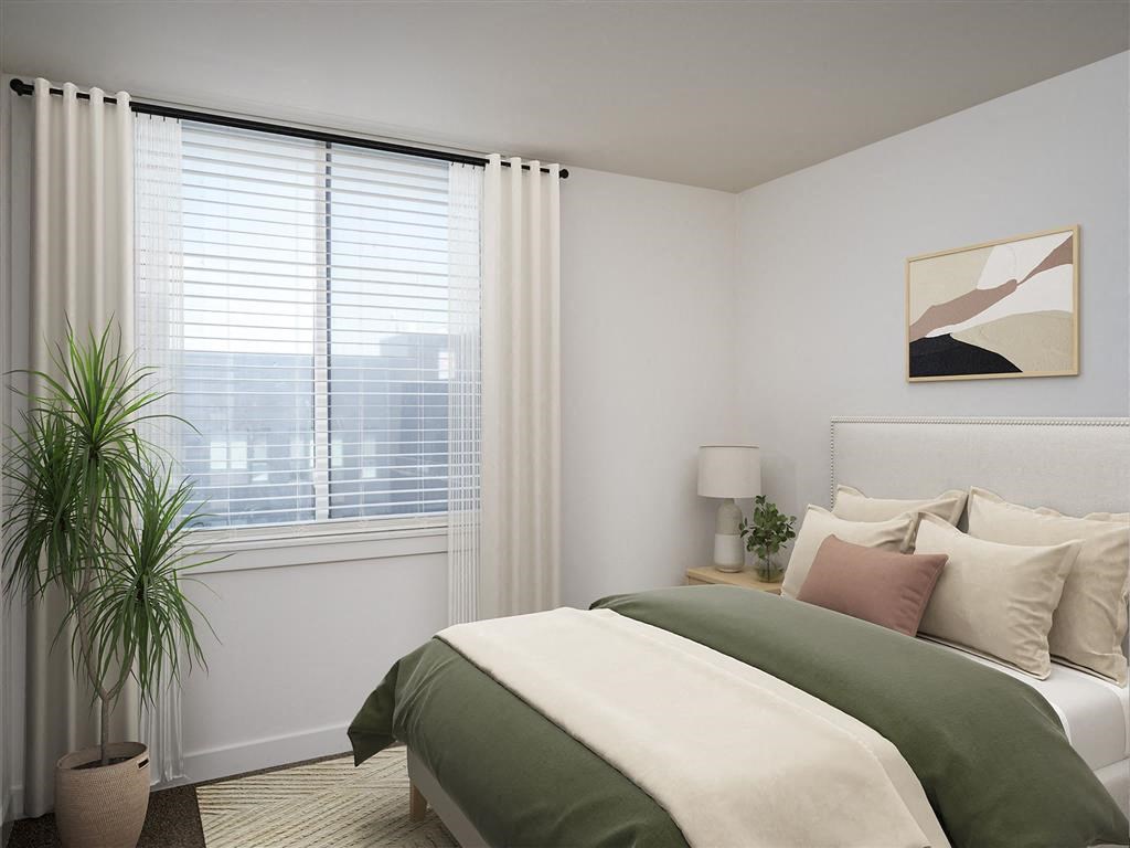 a bedroom with a bed and a window and a plant