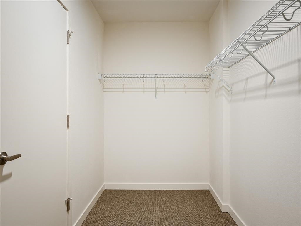 a room with white walls and a closet with wire shelving
