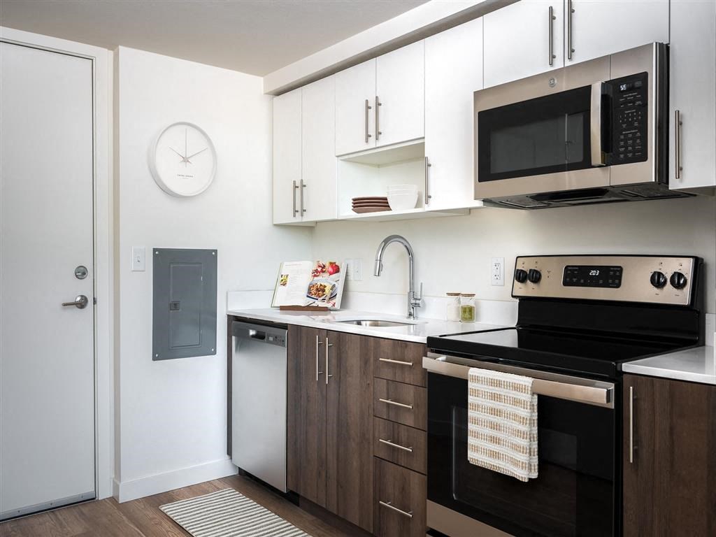 a kitchen with white cabinets and black appliances and a microwave