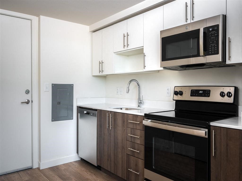 a kitchen with white cabinets and black appliances and a microwave