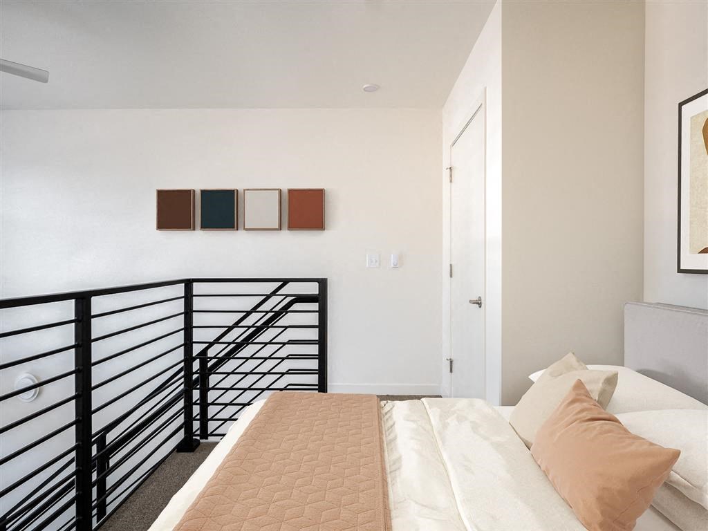 a bedroom with a bed and a railing in a small room