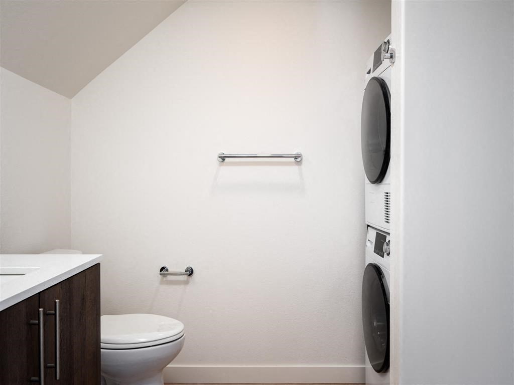 a bathroom with a toilet and a washing machine in it