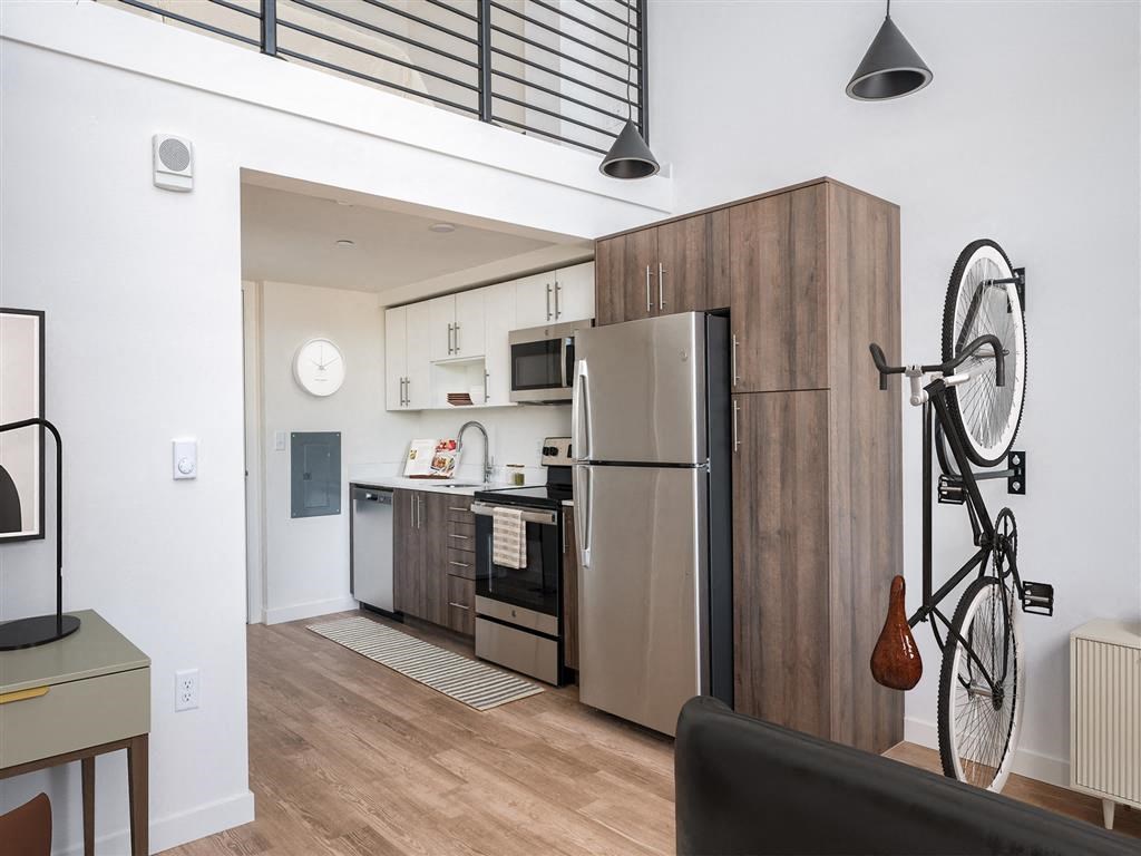a kitchen with stainless steel appliances and a bike on the wall