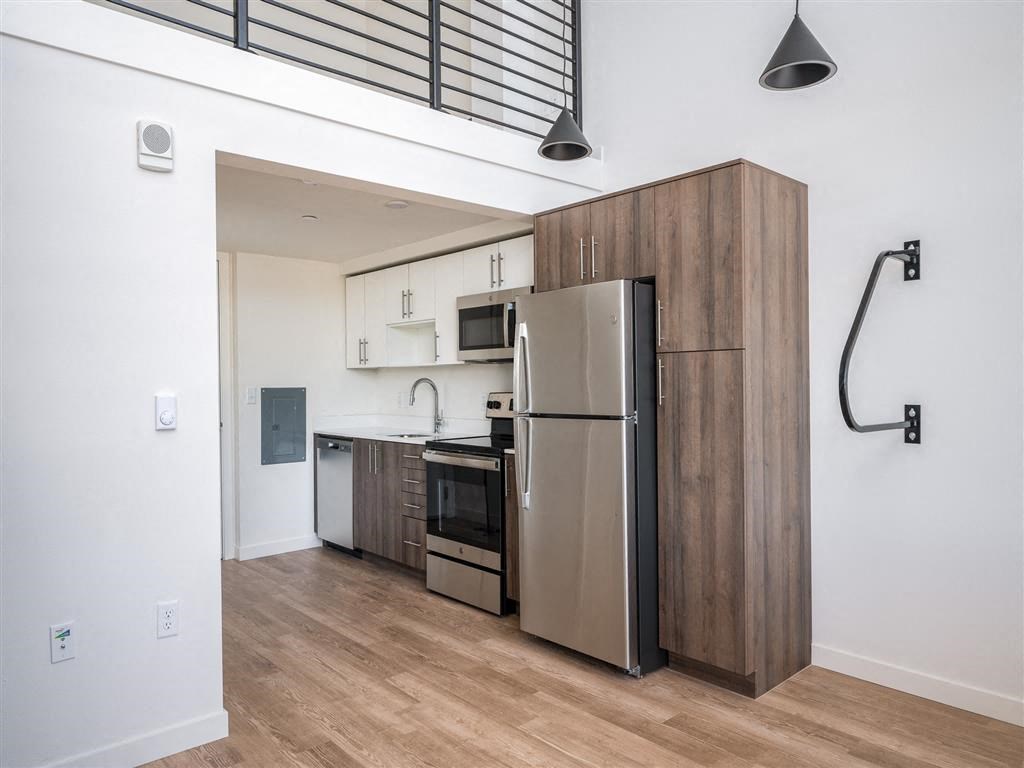 a kitchen with a stainless steel refrigerator and a wooden cabinet
