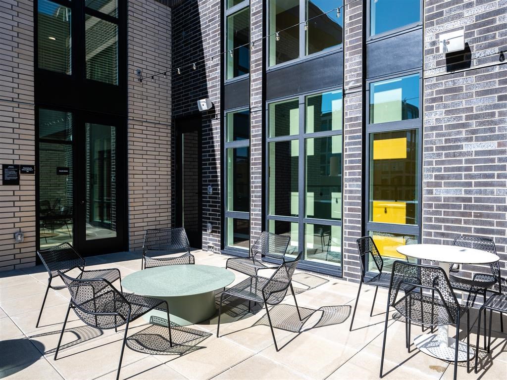 a patio with tables and chairs outside of a building