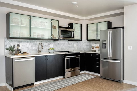 a kitchen with stainless steel appliances and black and white cabinets