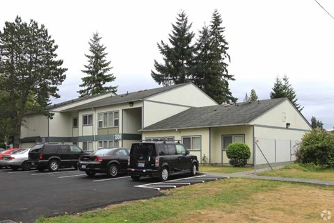 A parking lot with cars and a building in the background.