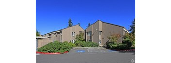 A large building with a parking lot in front.