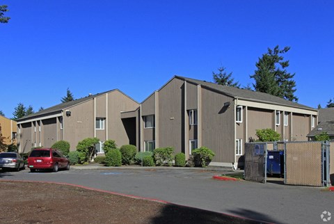 A large building with a parking lot in front.