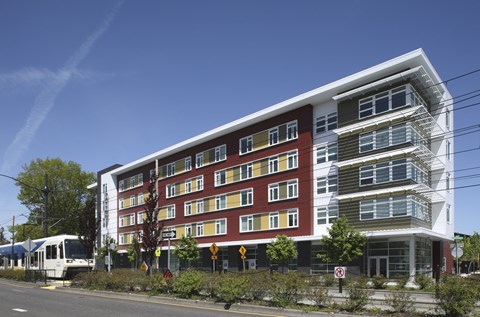 A modern multi-story building with a red and white facade.