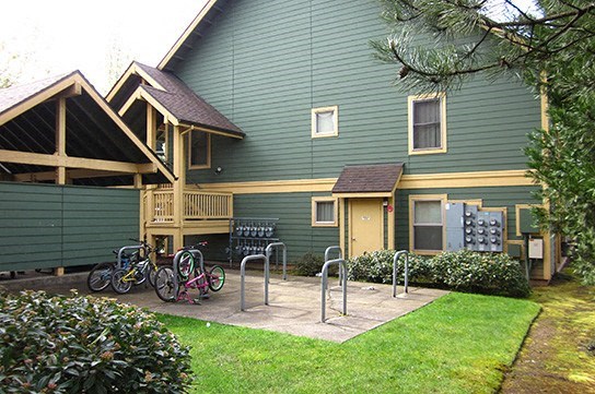 a green house with bikes parked outside of it