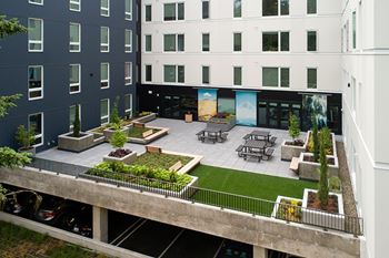 A rooftop patio with a table and chairs.