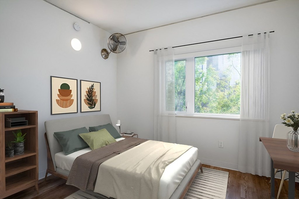 a bedroom with white walls and a bed with green pillows