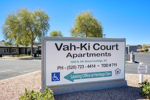 A sign for Vah-Ki Court Apartments is displayed in front of a building.