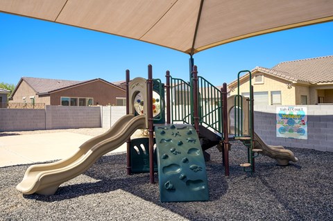 A playground with a slide and a climbing structure.