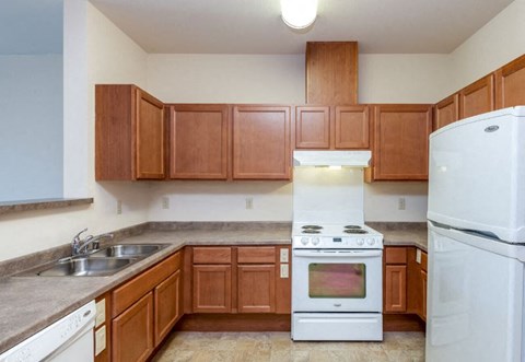 a kitchen with wooden cabinets and white appliances