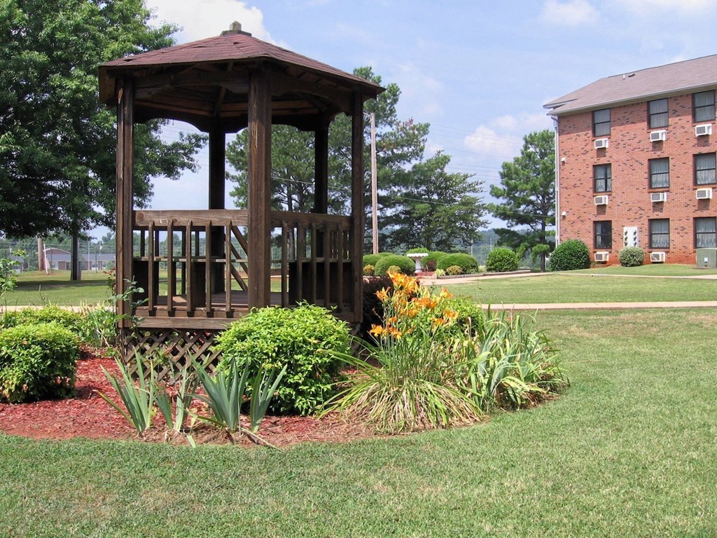 a gazebo surrounded by plants in the courtyard of Village Square Apartments in Russellville, AL