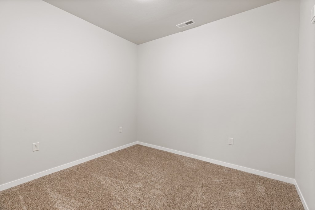 a spacious bedroom with plush carpeting