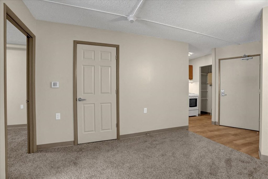 a living room with a white door and a door to a bedroom