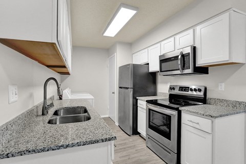 a kitchen with granite counter tops and stainless steel appliances