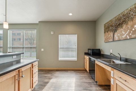 A kitchen with wooden cabinets and a black countertop.