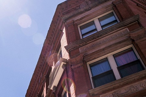 a tall brick building with a blue sky in the background