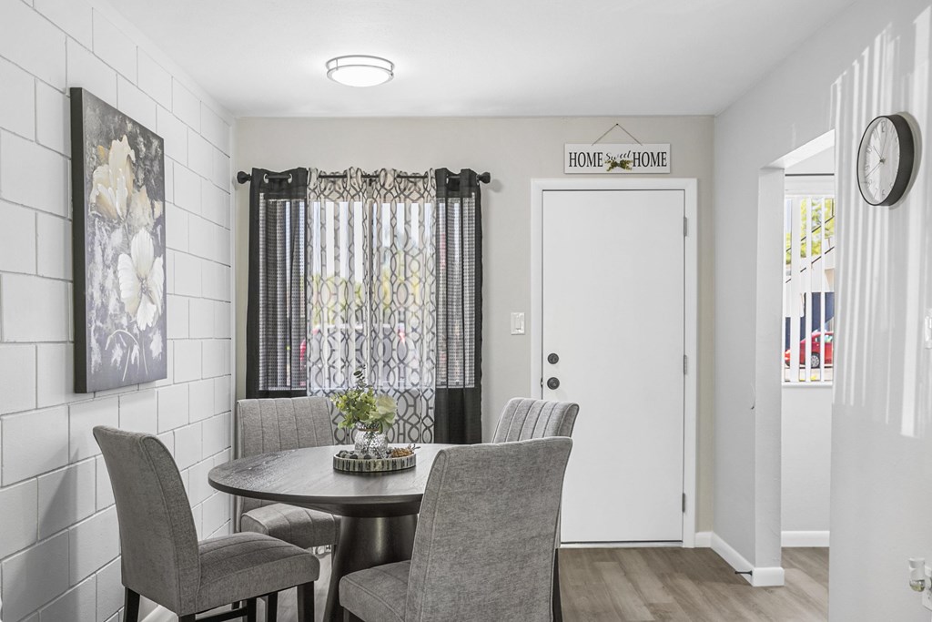A dining room with a table and chairs.