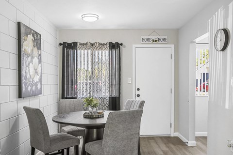 A dining room with a table and chairs.