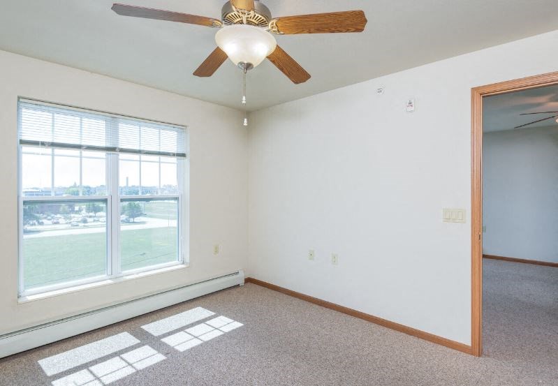 bedroom with large windows, ceiling fan, and closet