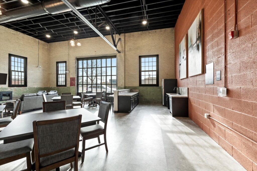 tables and chairs and a kitchenette in the community room at Brooke Street Lofts in Fond du Lac