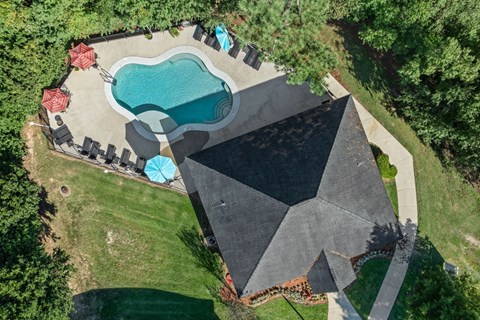 A backyard with a pool and a black tarp covering a structure.