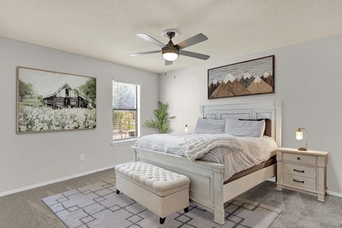 a large bedroom with plush carpeting, ceiling fan, window, and virtual furnishings at Rock Creek Apartments in Cordova, TN