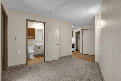 a living room with a door to a bathroom and a toilet