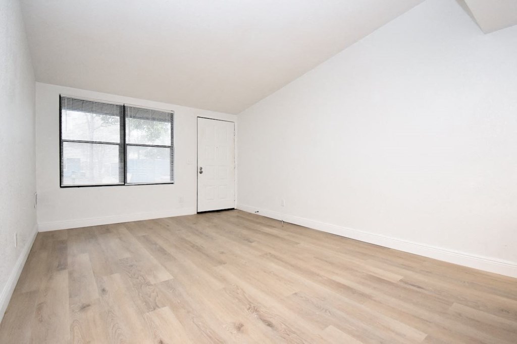 a room with wood-style floors and a large window