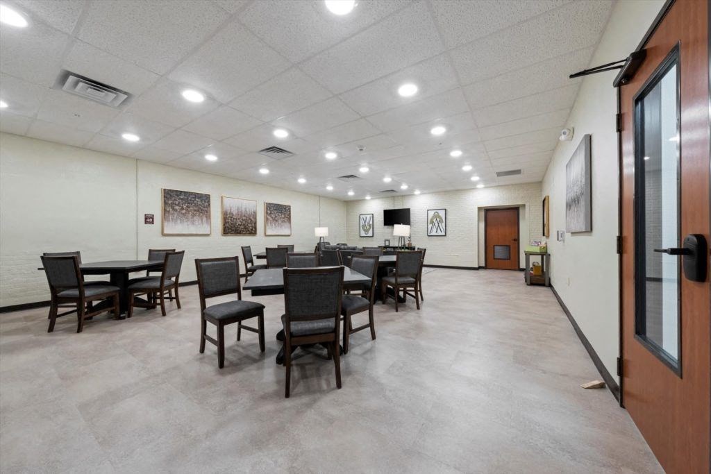a large community room with many tables and chairs