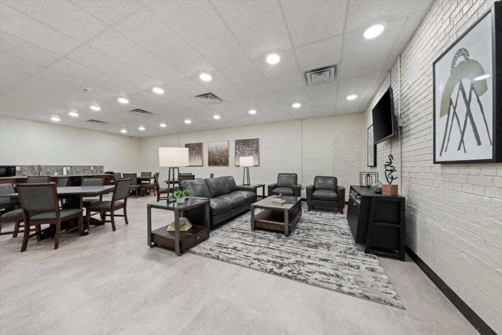 a spacious community room with seating and a TV