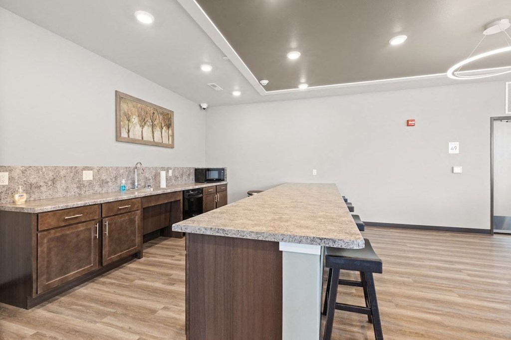 a kitchenette area in the community room in River Flats Apartments