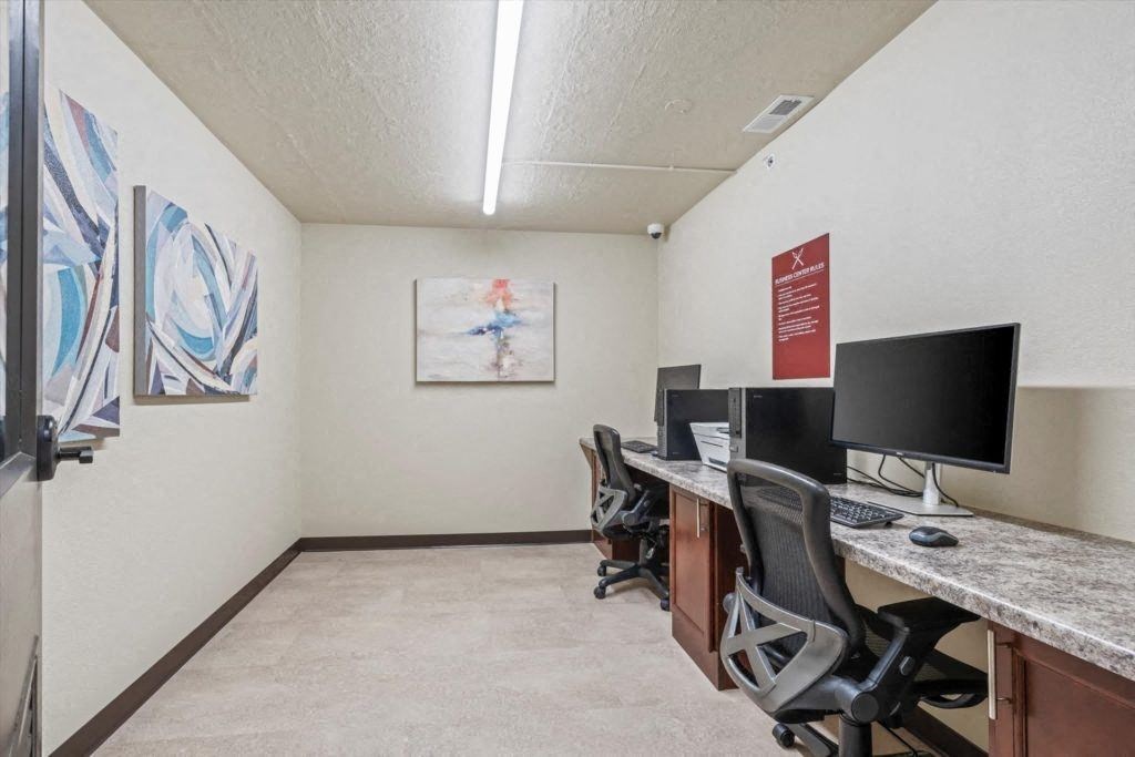 computers and chairs at a computer desk in the business center at Spartan Lofts