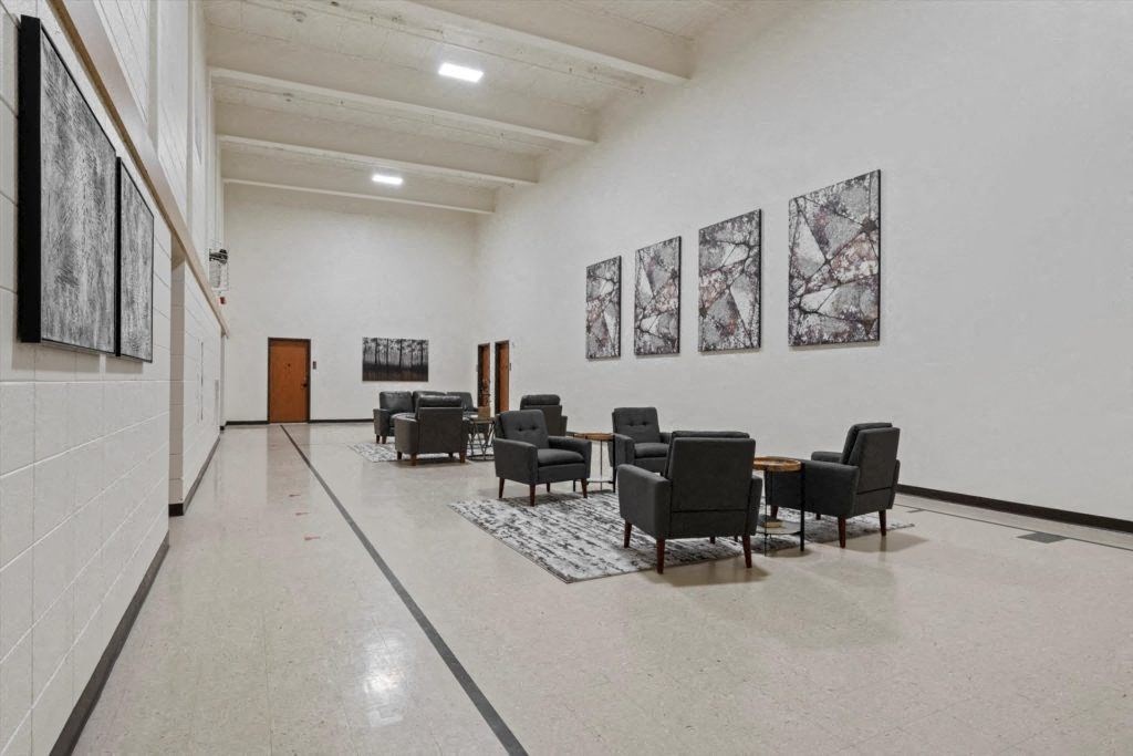 the large community room with seating and wall art at Spartan Lofts in Sparta, WI