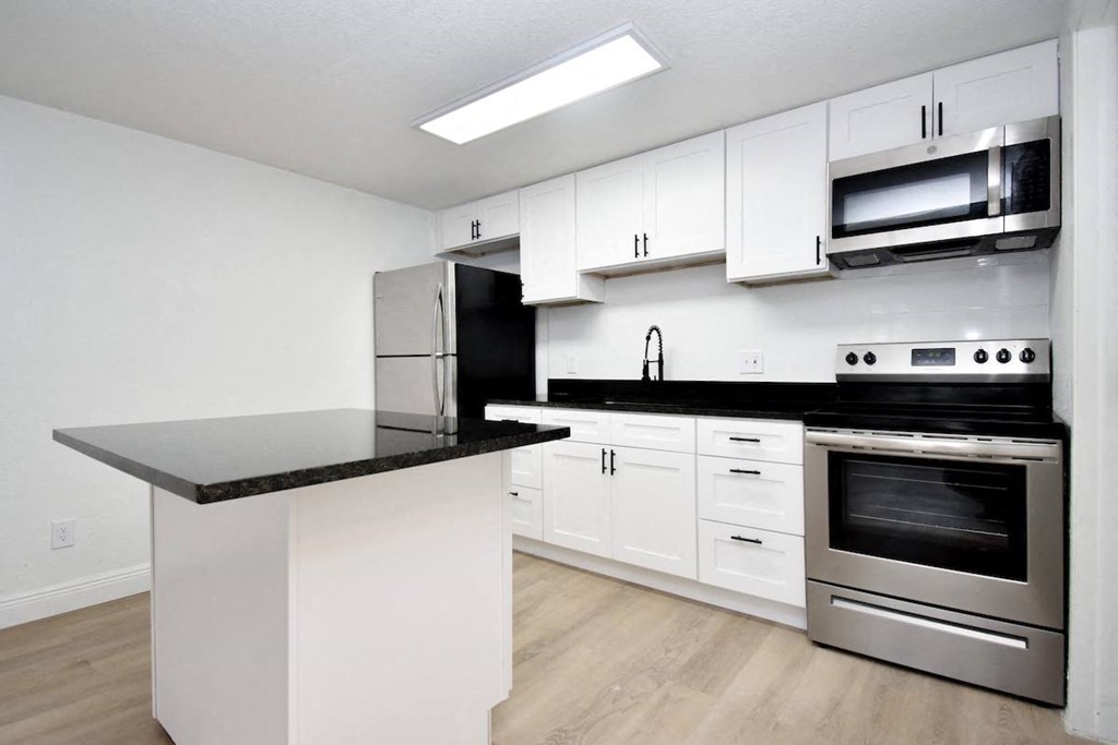a kitchen with white cabinets and stainless steel appliances