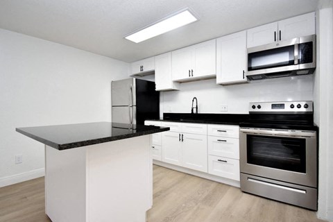 a kitchen with white cabinets and stainless steel appliances