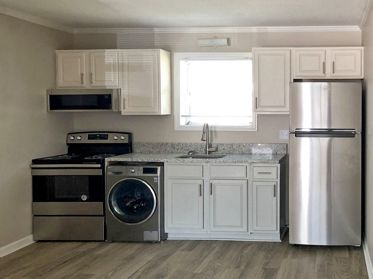 Kitchen with stainless steel stove, fridge, microwave, and washer dryer combo