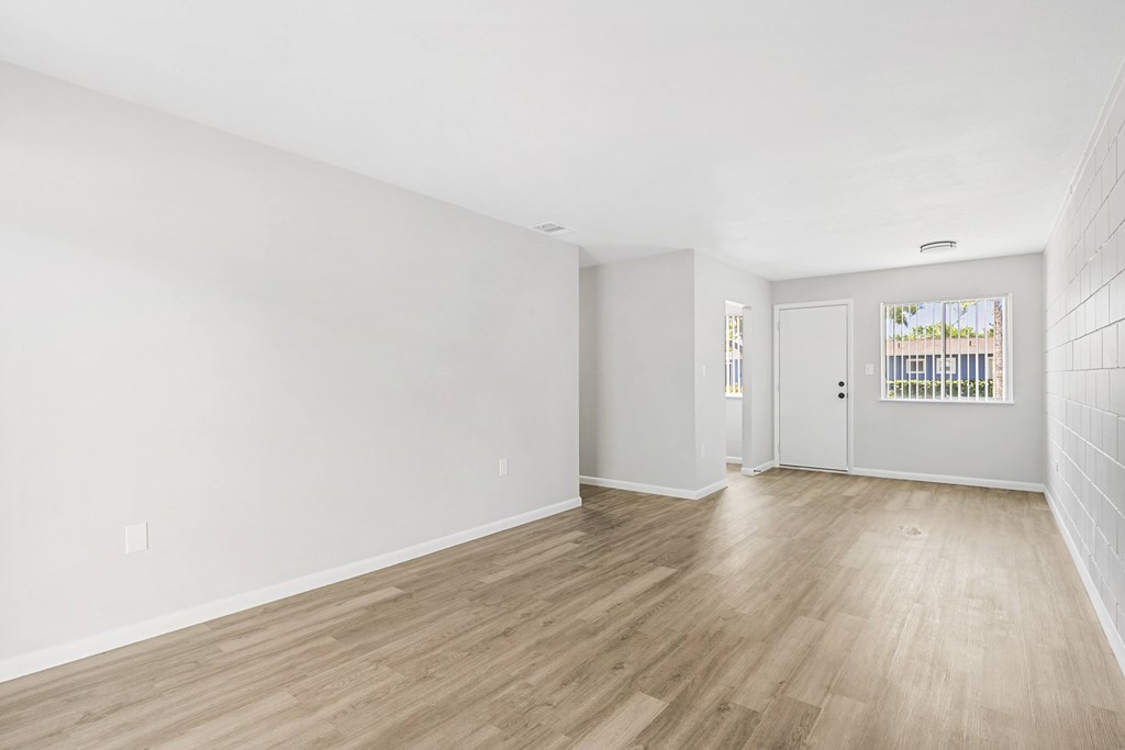 A room with wooden flooring and white walls.