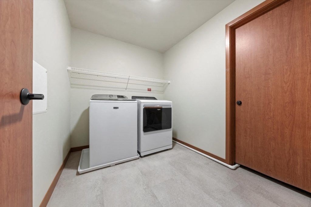 an in-home washer and dryer with built-in shelving in a Spartan Loft apartment for rent